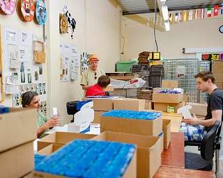 Freiwillige packen Kartons in einem Arbeitsraum.